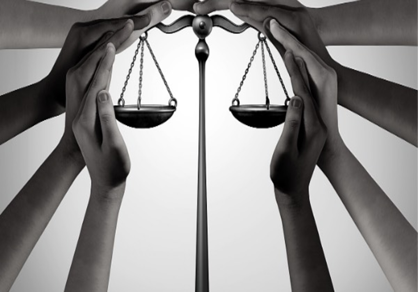 manos envolviendo la balanza de la justicia